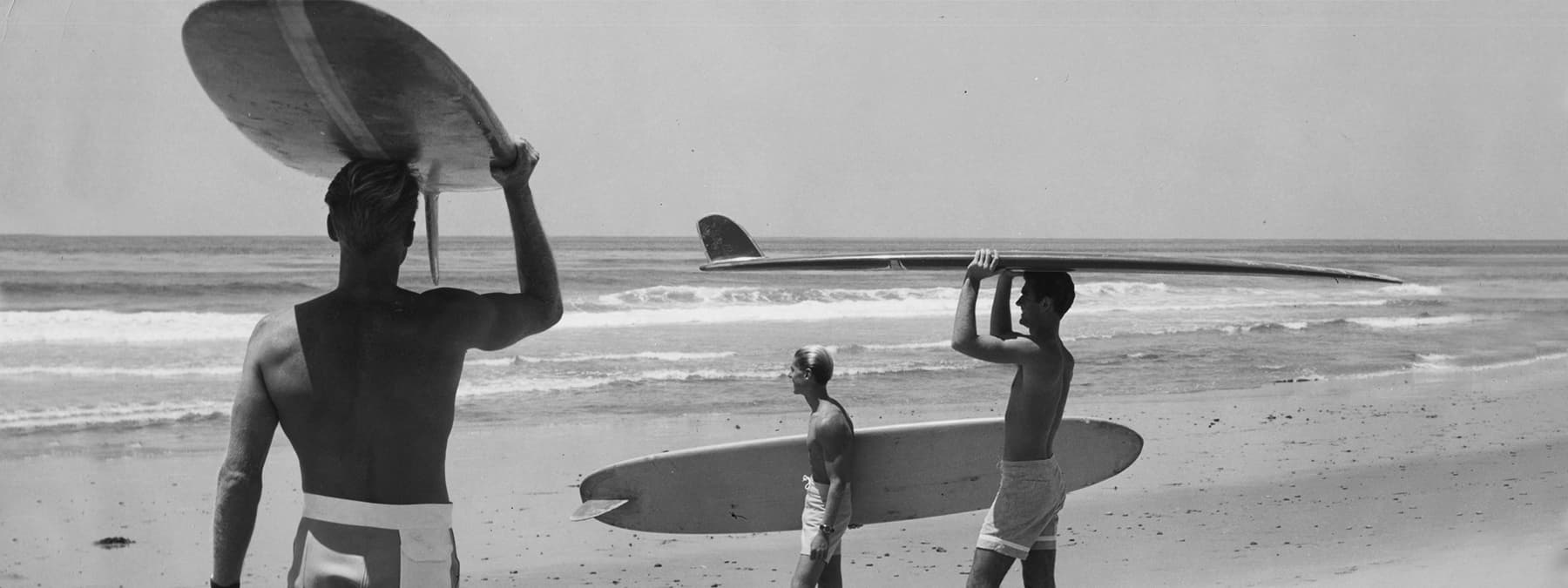 robert august and friends holding longboard surfboards